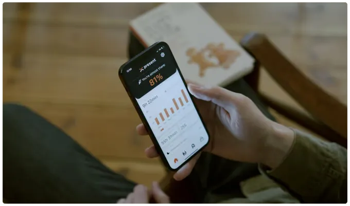 A hand holding a phone with the Present app, showing phone-free time.