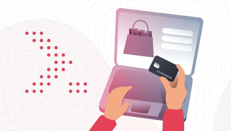 Hands holding a bank card over a laptop that shows a shopping bag, beside a pattern of coral dots.