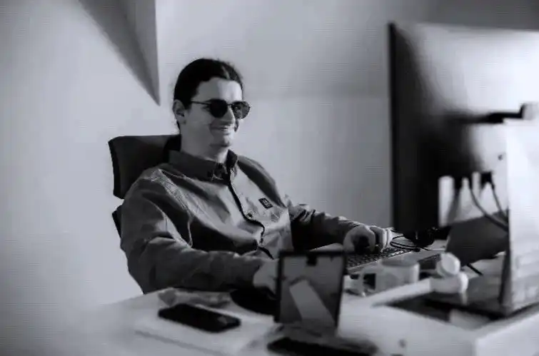 A colleague smiling at his desk in the Cluj-Napoca office.