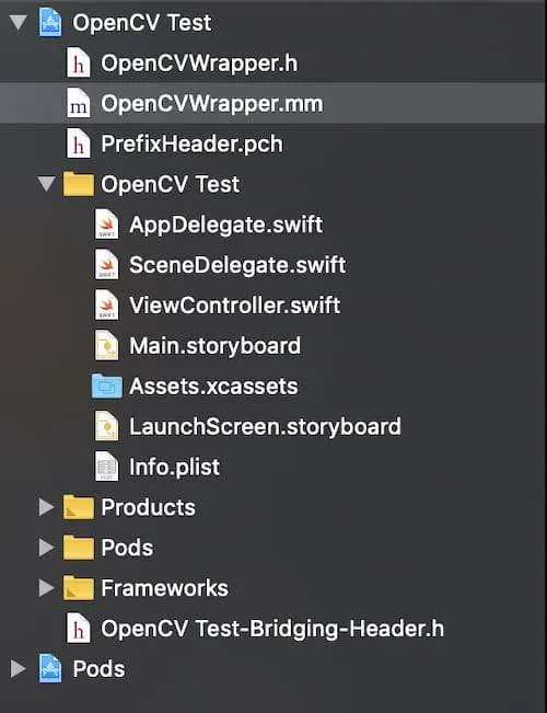 The Xcode project navigator for OpenCV Test, listing OpenCVWrapper.h, OpenCVWrapper.mm and PrefixHeader.pch above the app’s files and the bridging header.